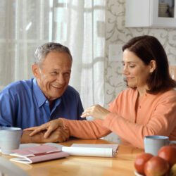 Woman and older man sitting at a table.