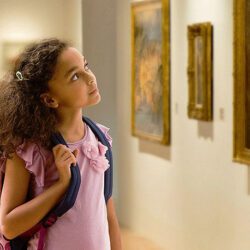Young girl stares at art in a museum.