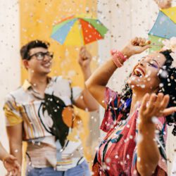 A group of people laugh under falling confetti as they celebrate Hispanic Heritage month.