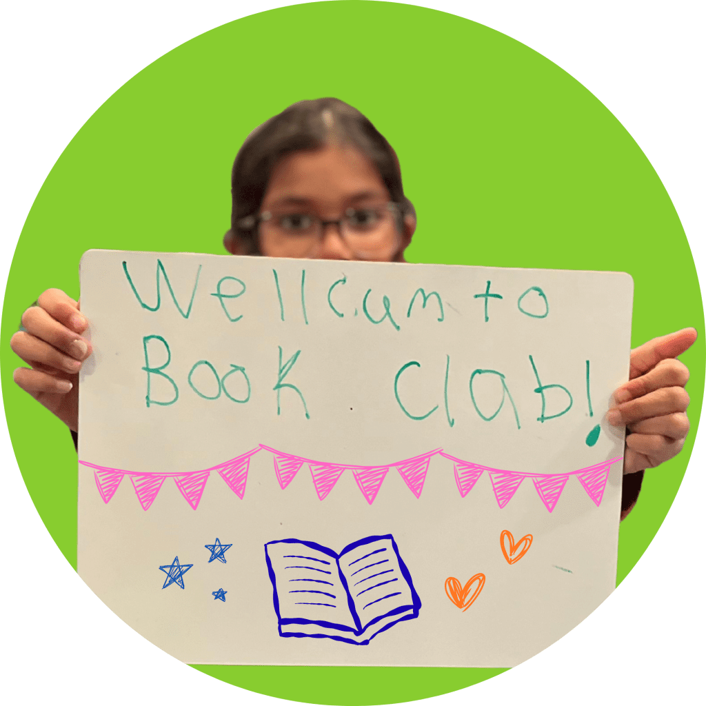 Child holding a sign that says "welcome to book club."