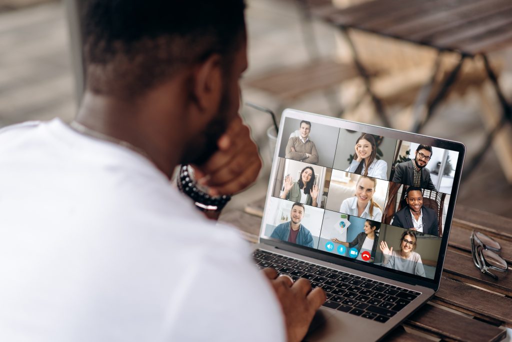 Man on a conference call, viewing everyone on a laptop screen.