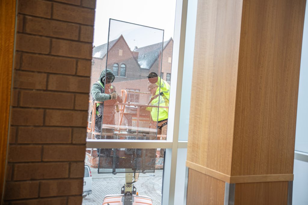 Workers removing part of a window.